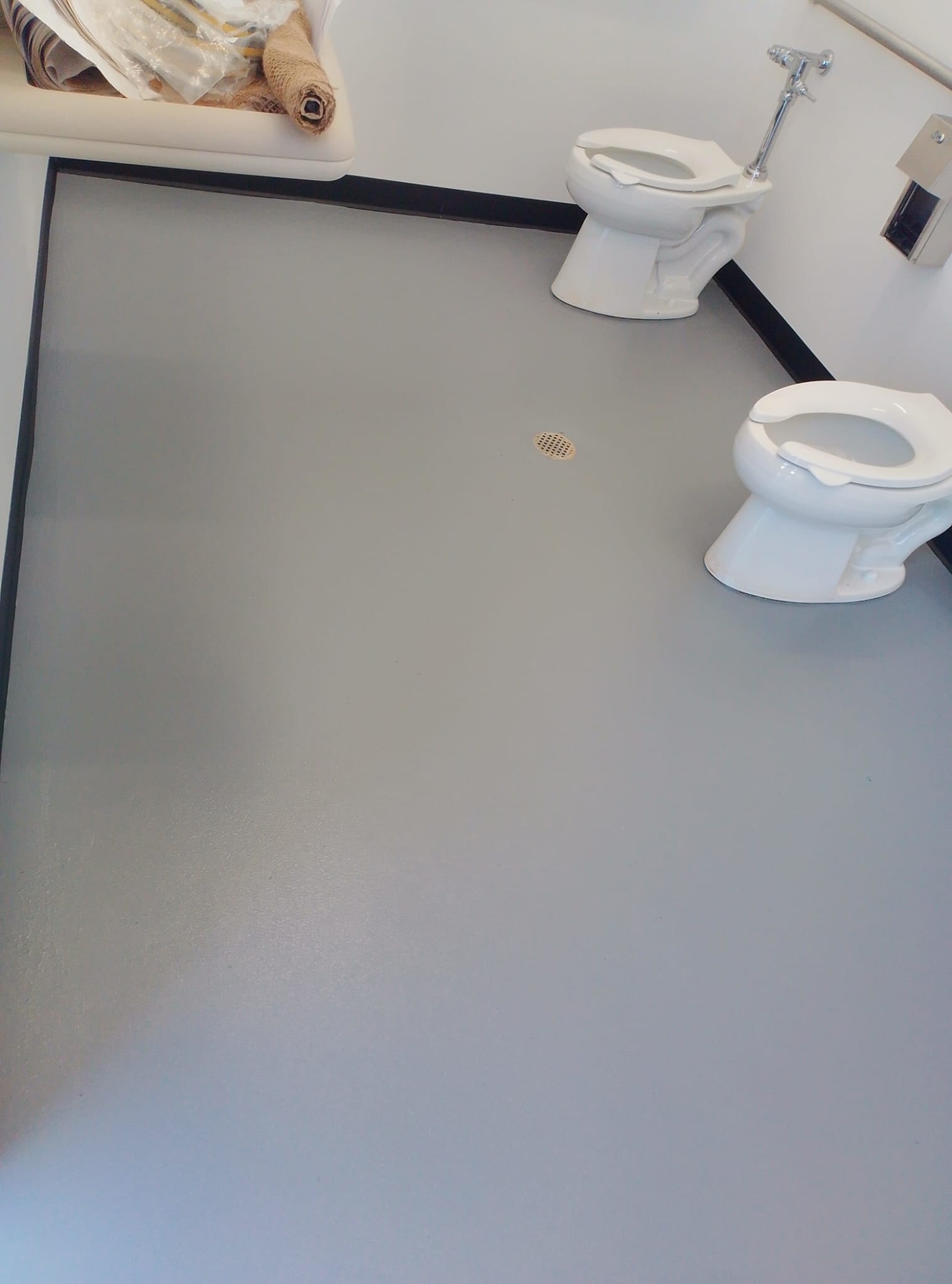 Finished resilient floor coating in a commercial bathroom